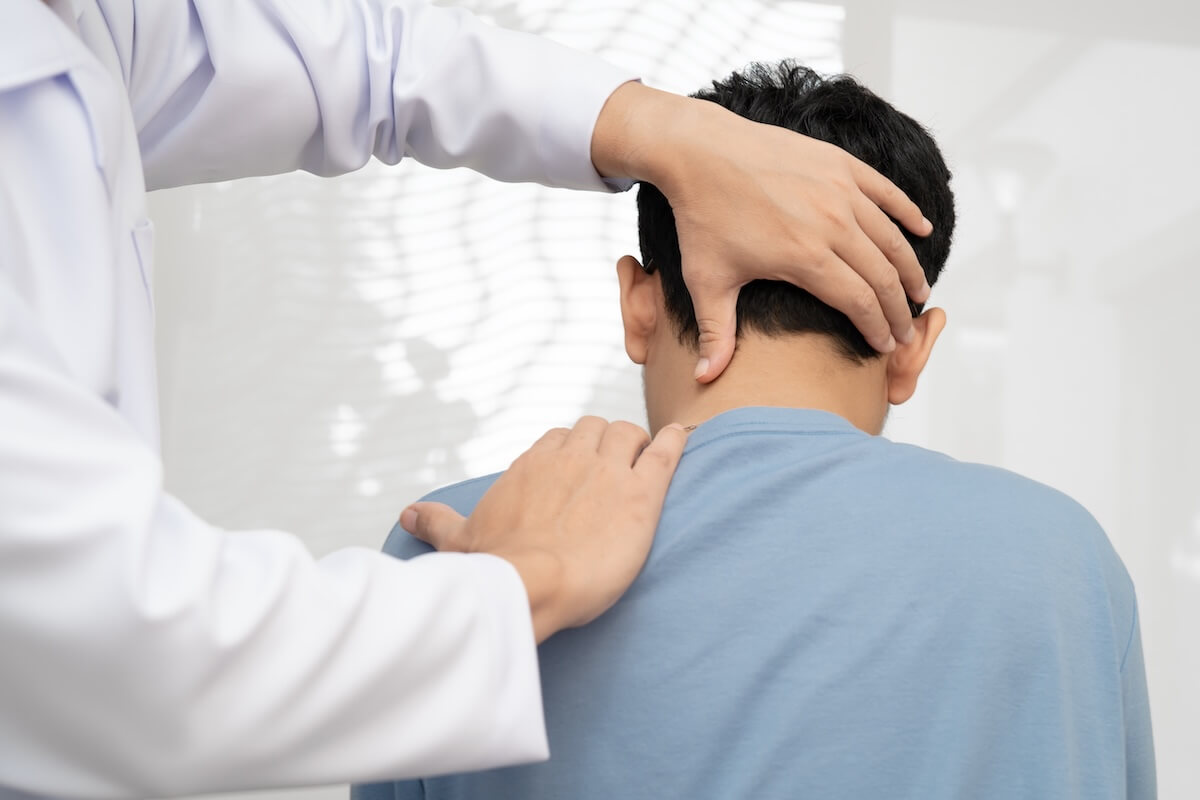 Chiropractor performing a neck adjustment on a patient during treatment