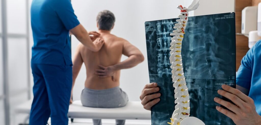 doctor examining patients back for scoliosis.