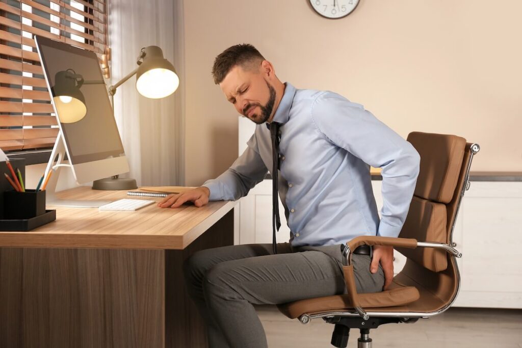 Desk job back pain from poor sitting posture at office workstation