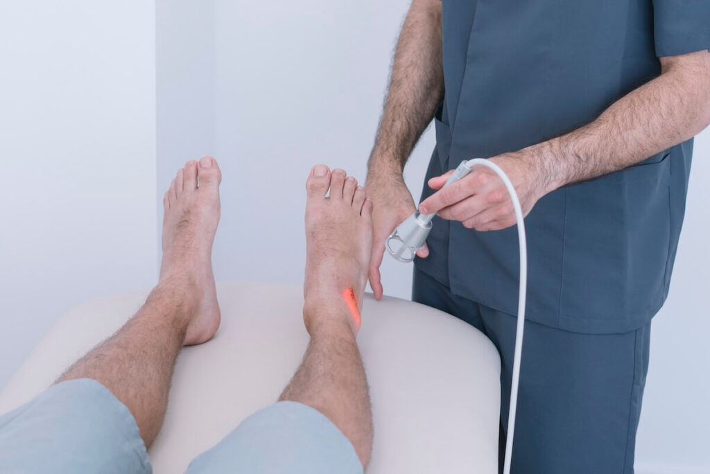physical therapist using class iv laser on patient